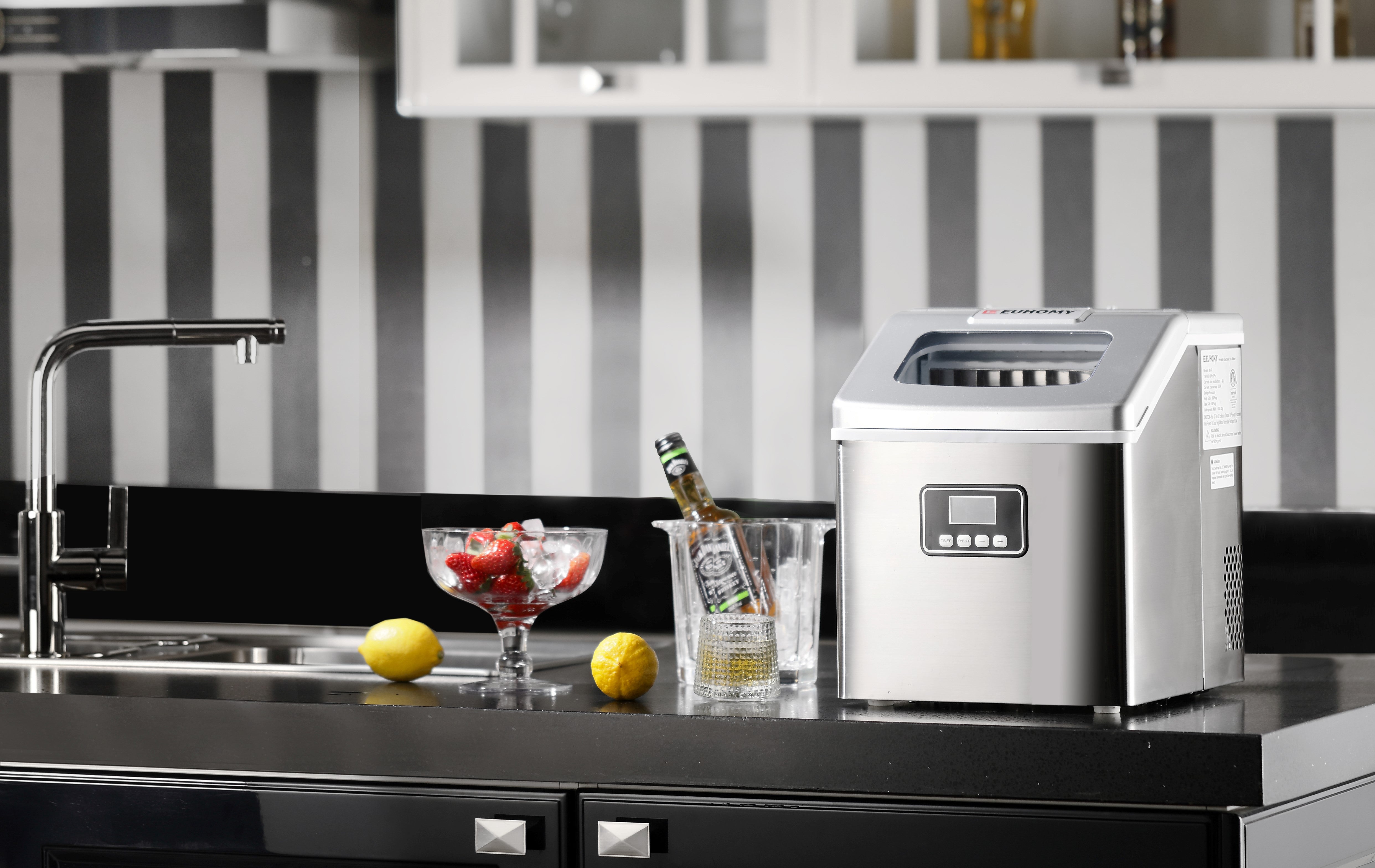 Euhomy portable ice maker providing fresh ice for a bowl of strawberries and chilled beverages on a modern kitchen counter.